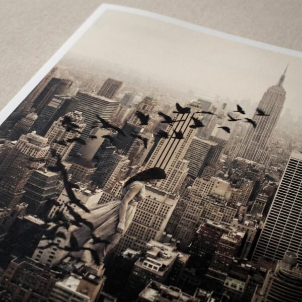Une femme suspendue au-dessus de Manhattan se transforme en envolée d'oiseaux. Cette œuvre de photographie conceptuelle capture un instant de transition poétique où le corps humain fusionne avec le ciel, défiant les structures rigides des gratte-ciel new-yorkais.