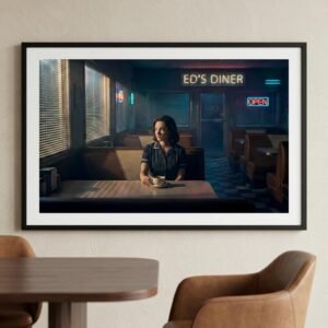 Sous le néon vacillant d'un diner désert, une femme s'égare dans les reflets sombres de son café tandis que le monde extérieur s'efface derrière les persiennes. L'heure est au bilan ou à l'attente, dans ce sanctuaire urbain où chaque ombre semble porter le poids d'un secret non formulé au milieu de la nuit.