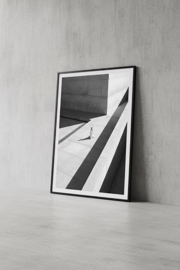 Une silhouette d'ivoire s'égare dans un labyrinthe de béton, où le temps semble suspendu aux plis de sa robe. Sous un soleil de plomb, les ombres dessinent une géométrie implacable, transformant la ville en un sanctuaire désert. Entre mode et architecture, cette scène invite à une déambulation onirique au carrefour de la mémoire et du style.