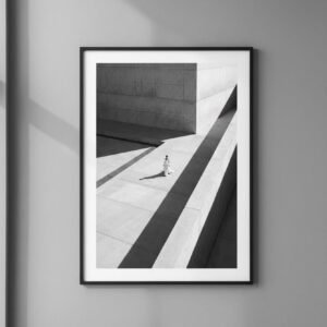 Une silhouette d'ivoire s'égare dans un labyrinthe de béton, où le temps semble suspendu aux plis de sa robe. Sous un soleil de plomb, les ombres dessinent une géométrie implacable, transformant la ville en un sanctuaire désert. Entre mode et architecture, cette scène invite à une déambulation onirique au carrefour de la mémoire et du style.