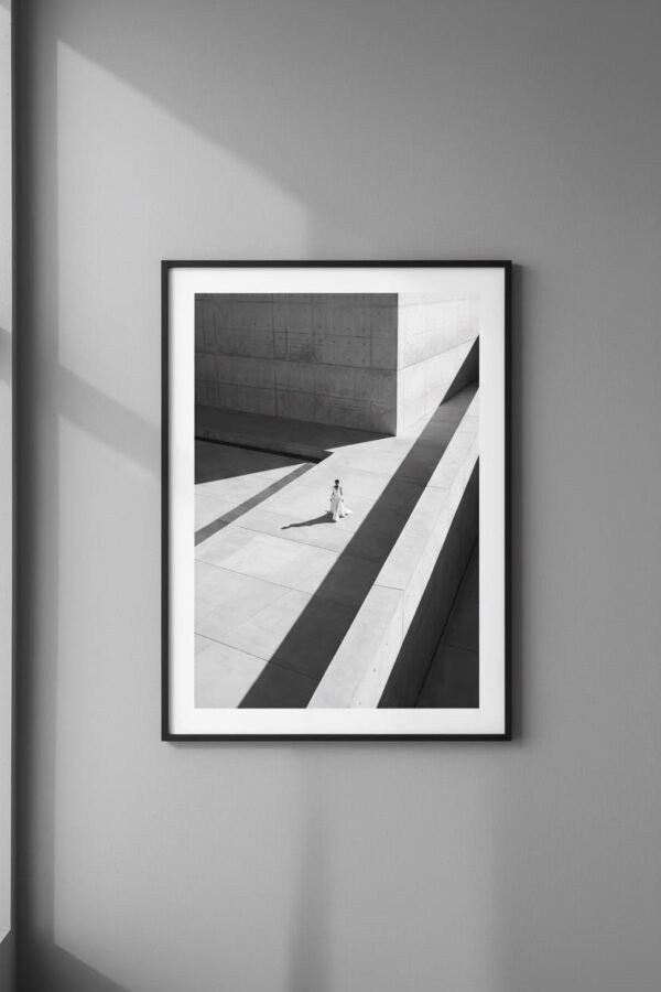 Une silhouette d'ivoire s'égare dans un labyrinthe de béton, où le temps semble suspendu aux plis de sa robe. Sous un soleil de plomb, les ombres dessinent une géométrie implacable, transformant la ville en un sanctuaire désert. Entre mode et architecture, cette scène invite à une déambulation onirique au carrefour de la mémoire et du style.