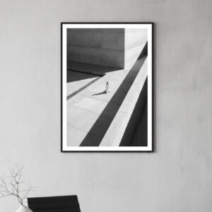 Une silhouette d'ivoire s'égare dans un labyrinthe de béton, où le temps semble suspendu aux plis de sa robe. Sous un soleil de plomb, les ombres dessinent une géométrie implacable, transformant la ville en un sanctuaire désert. Entre mode et architecture, cette scène invite à une déambulation onirique au carrefour de la mémoire et du style.