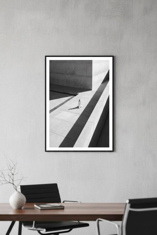 Une silhouette d'ivoire s'égare dans un labyrinthe de béton, où le temps semble suspendu aux plis de sa robe. Sous un soleil de plomb, les ombres dessinent une géométrie implacable, transformant la ville en un sanctuaire désert. Entre mode et architecture, cette scène invite à une déambulation onirique au carrefour de la mémoire et du style.