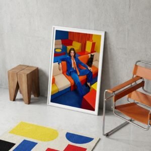 Dans une pièce où chaque couleur semble avoir été choisie comme un argument, une femme s'étale avec l'assurance tranquille de quelqu'un qui n'a plus rien à prouver. À ses côtés, un chat noir observe. L'espace autour d'elle n'est pas un décor — c'est un manifeste silencieux.