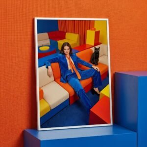 Dans une pièce où chaque couleur semble avoir été choisie comme un argument, une femme s'étale avec l'assurance tranquille de quelqu'un qui n'a plus rien à prouver. À ses côtés, un chat noir observe. L'espace autour d'elle n'est pas un décor — c'est un manifeste silencieux.