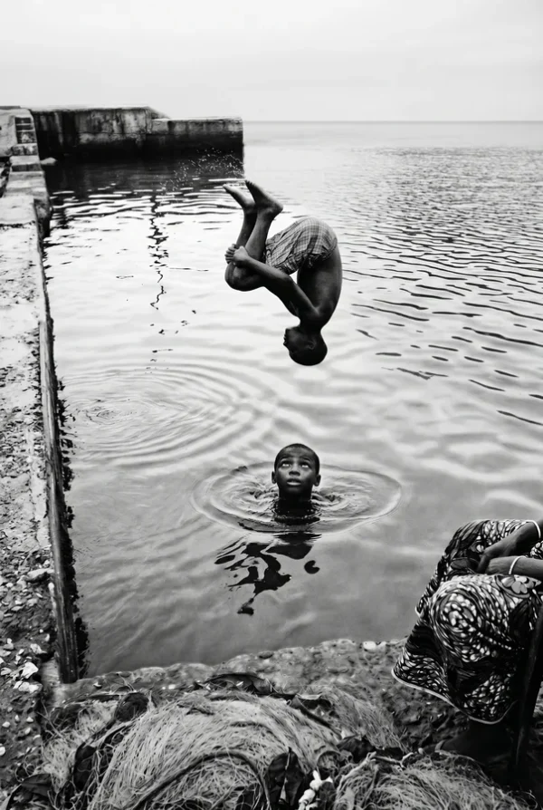 La pirouette, Sénégal : enfant faisant un saut (photo noir et blanc)